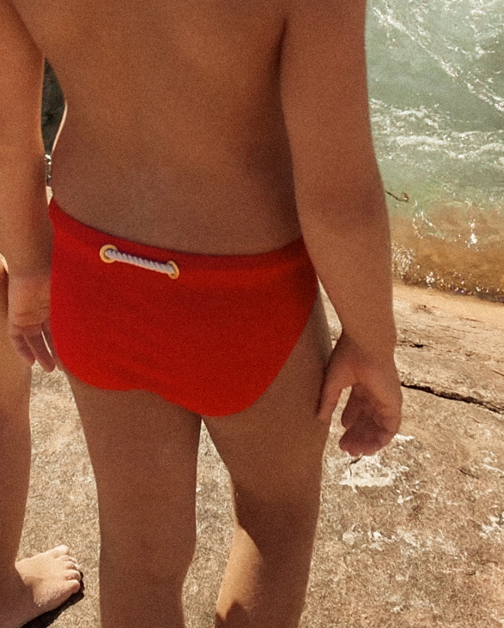 Close-up of a child wearing red Lobby’s Nippers, highlighting the signature rope detail at the back waistband.