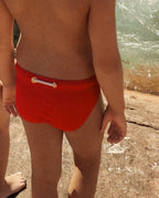 Close-up of a child wearing red Lobby’s Nippers, highlighting the signature rope detail at the back waistband.