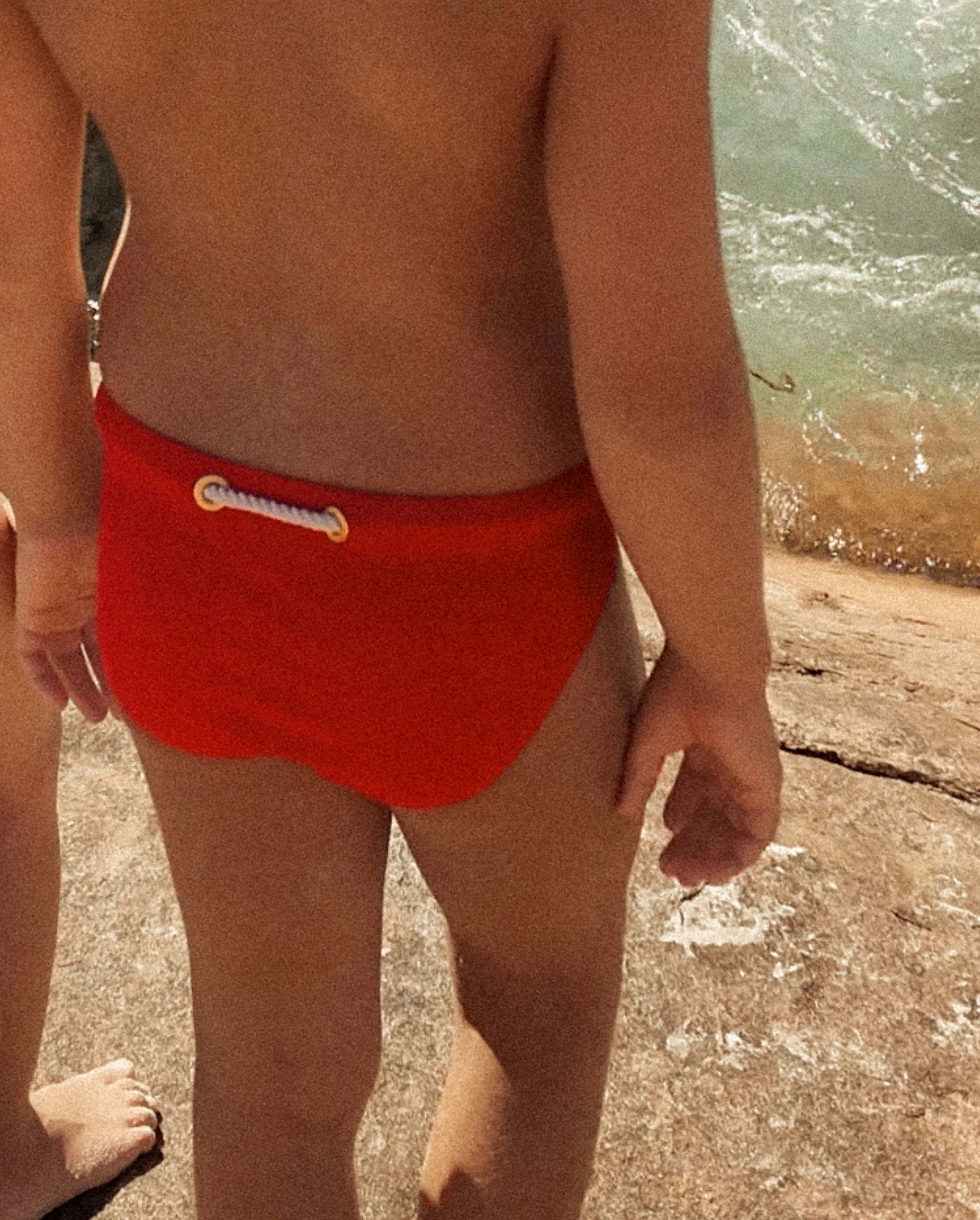 Close-up of a child wearing red Lobby’s Nippers, highlighting the signature rope detail at the back waistband.