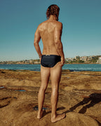 Model wearing Lobby’s black swim briefs back – sleek, timeless vintage look