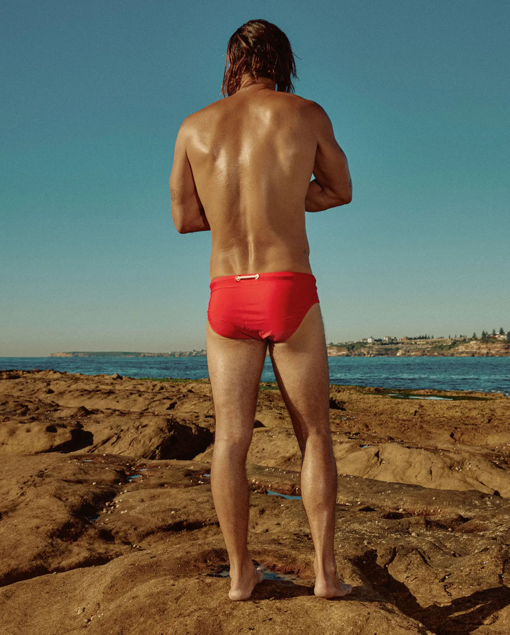 Model wearing Lobby’s red swim briefs – bold and refined vintage aesthetic - back view