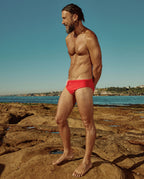 Model wearing Lobby’s red swim briefs side – bold and refined vintage aesthetic
