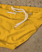 Close-up detail of yellow Lobby’s swimwear fabric, showcasing smooth texture and refined stitching.