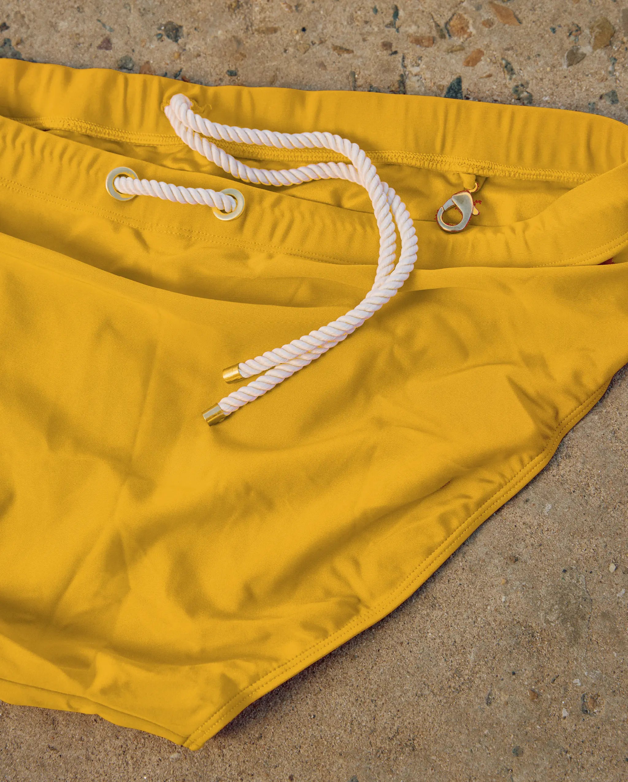 Close-up detail of yellow Lobby’s swimwear fabric, showcasing smooth texture and refined stitching.